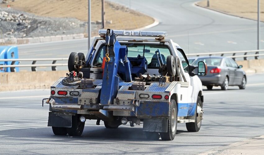 Tow truck driving on a highway.