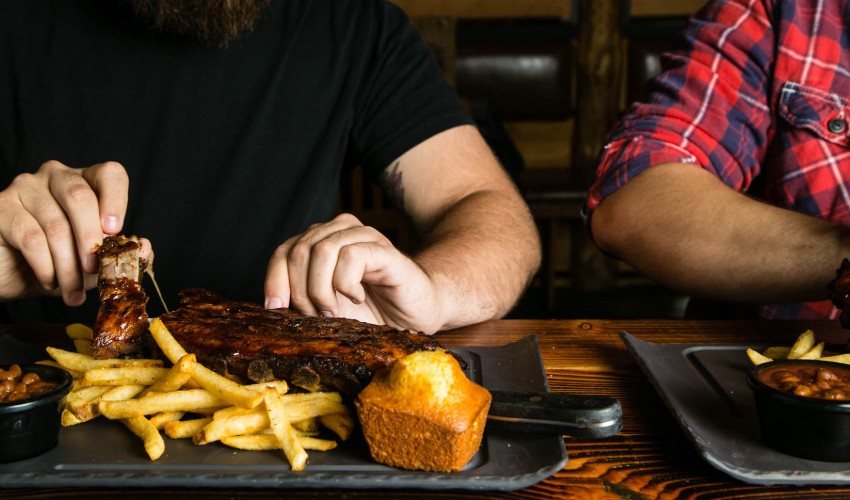 Man eating a plate of Montana's ribs.