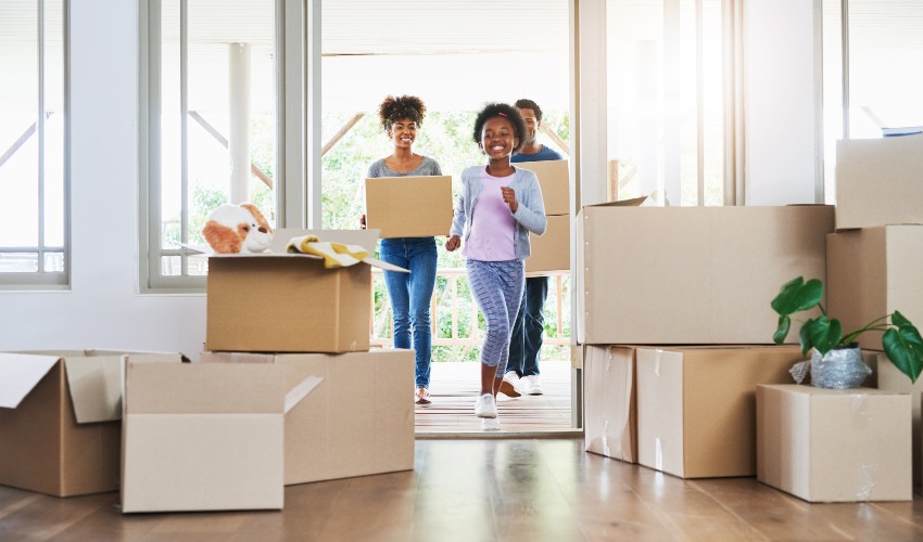Happy family carrying boxes into their new home.