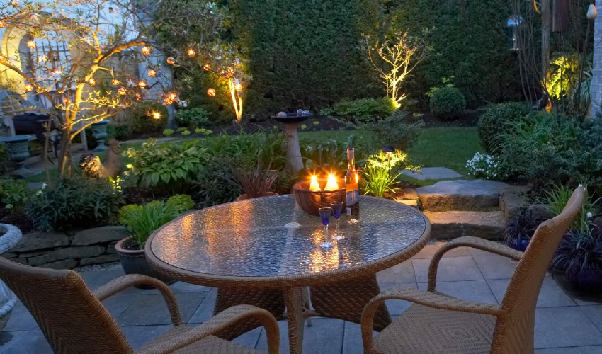 Backyard patio at dusk lit with outdoor lights and electric candles.