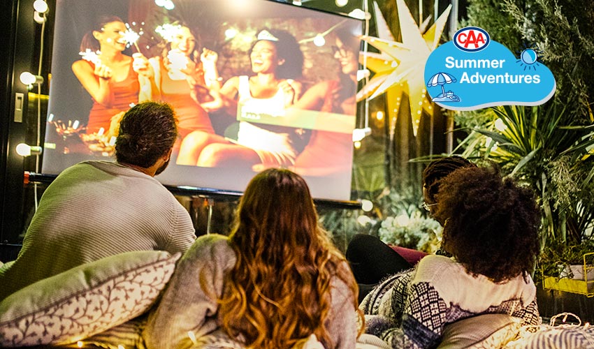 Man and two women watching outdoor movie