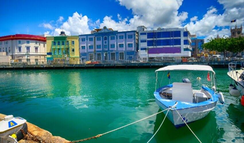 Boat in marina, houses in background in Barbados.