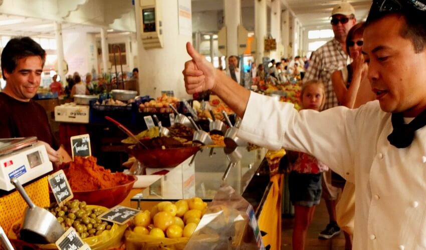 Chef interacting with customers at a market.