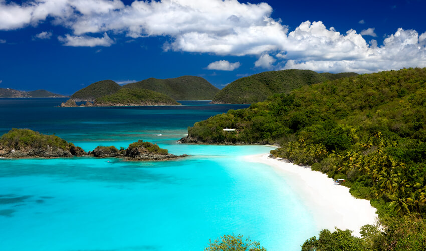 Aerial view of the clear turquoise waters and white sand cove at Trunk Bay Beach in St. John, US Virgin Islands.