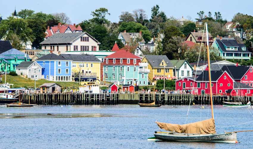 Shoreline view of brightly coloured houses along the boat-lined harbour in Lunenburg, Nova Scotia