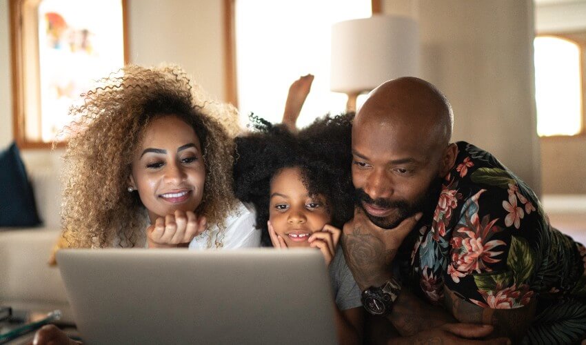 Happy family watching a movie on a laptop.