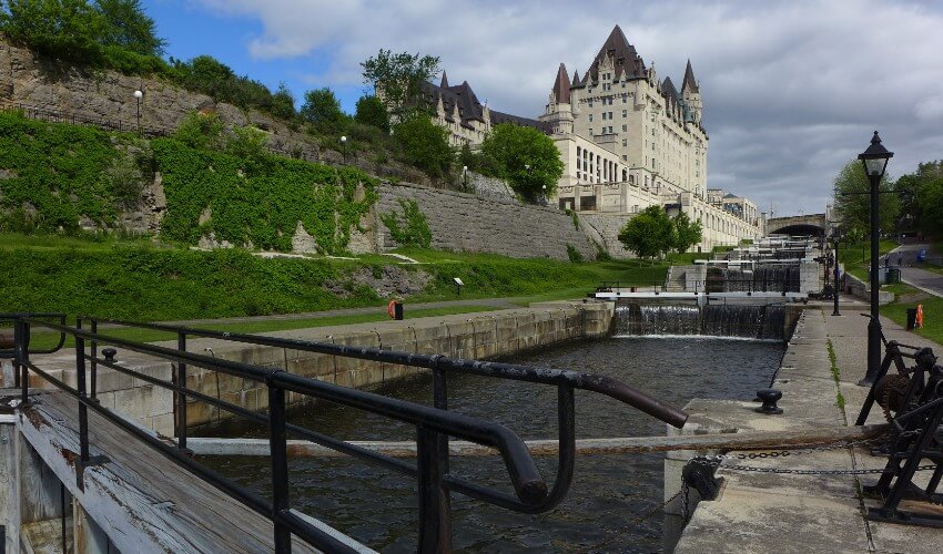 Locks on the Rideau Canal, with boardwalks on both sides and Chateau Laurier hotel in background.