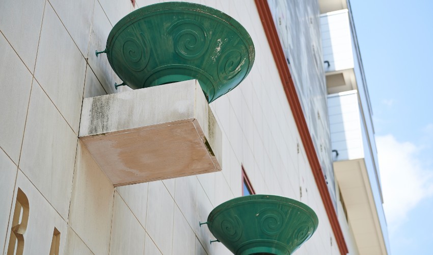 Decorative green ramen bowls perched up on the side of the ramen museum in Japan.
