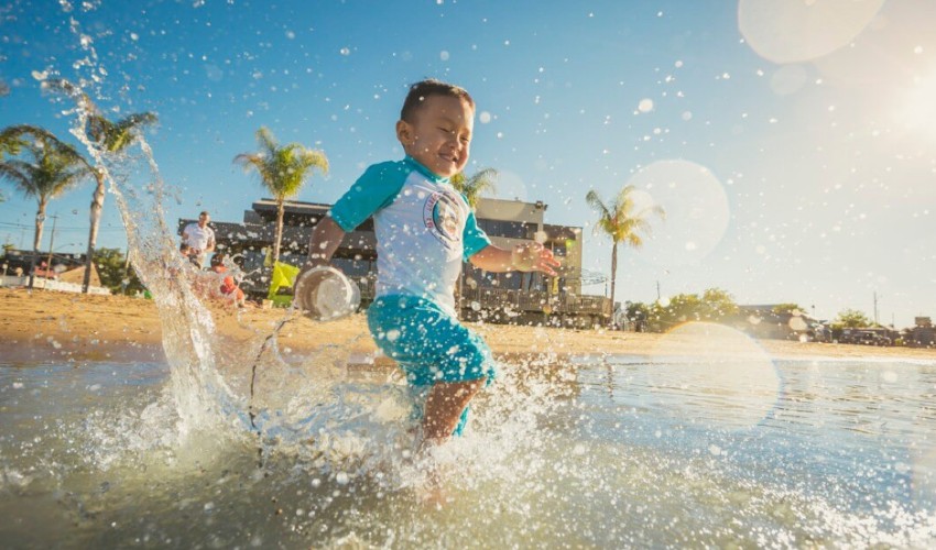 Young boy splashing in water at Port Dover Ontario.