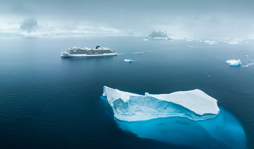 Viking ocean cruise ship surrounded by icebergs.