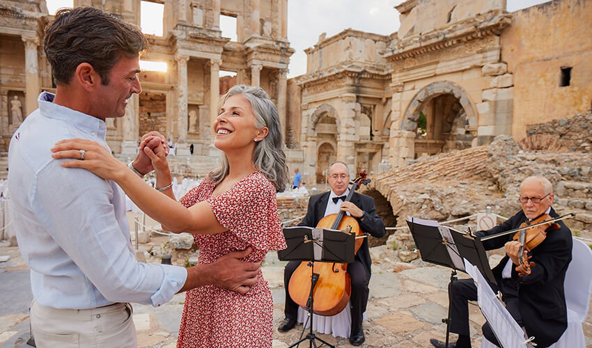 Couple dancing in ancient piazza as musicians play.