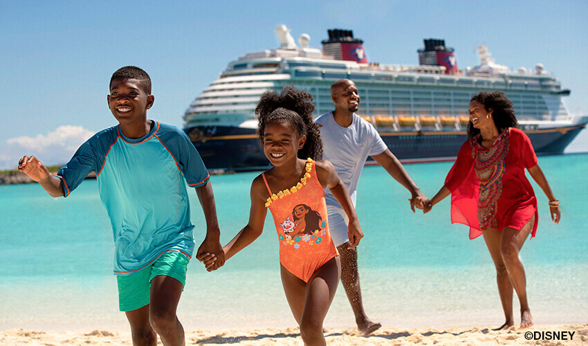 Family of four on beach with Disney cruise ship in background.