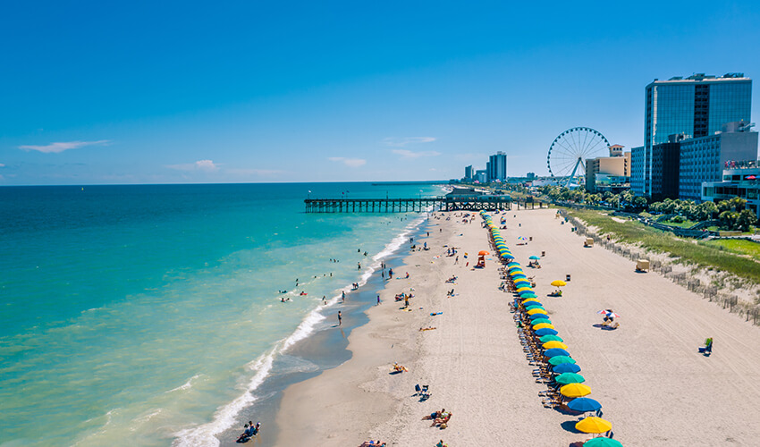 Myrtle beach view from a drone with colourful umbrellas in sight.