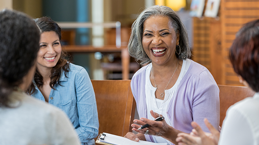 Smiling woman sitting with group of other women