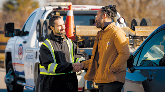 Member and tow truck operator talking