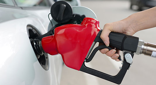 Person holding a gas pump, pumping gas into car