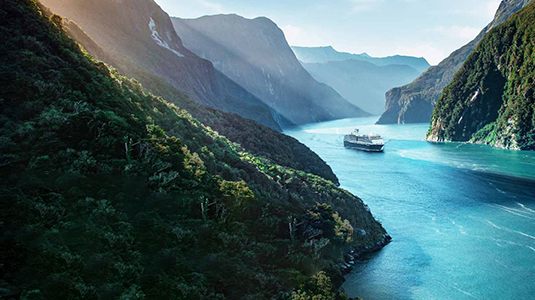 Cruise ship in the river surrounded by mountains