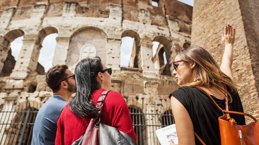 Guide explaining to tourists the Coliseum of Rome