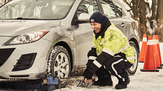 Tow truck driver preparing to tow a car