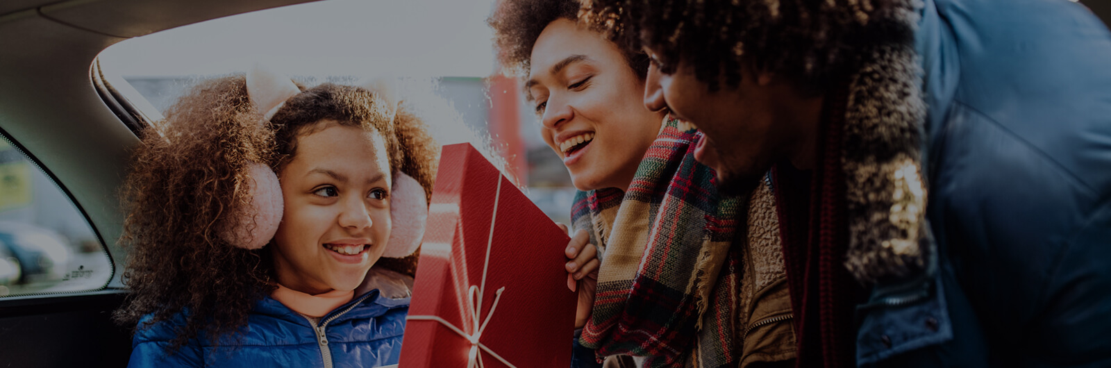 family looking at gifts in car