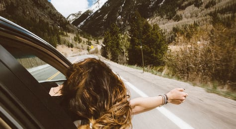 Woman in car with arm out of window