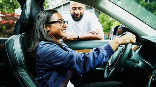 Father watching daughter drive car