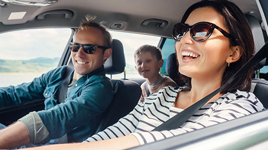 Woman driving family in car