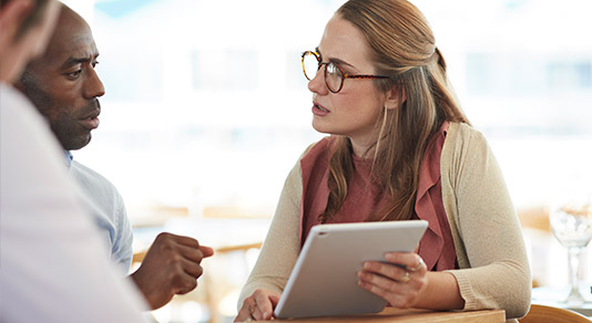 Client and agent discussing while looking at a tablet