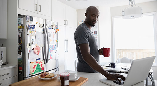 Man on his laptop in his kitchen