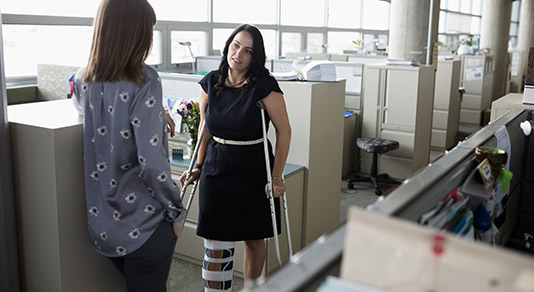 Woman with a broken leg at the office
