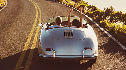 Woman's arms in the air in the convertible