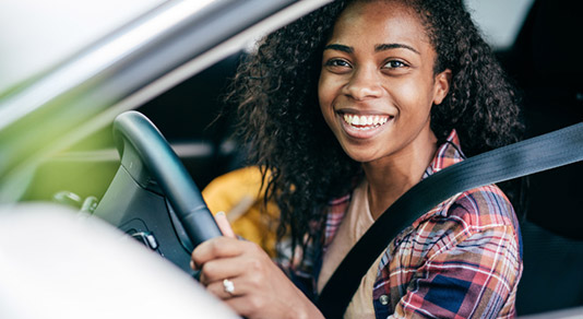 Girl smiling behind the wheel of a car