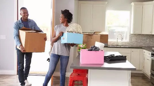 Couple movoing boxes into their home