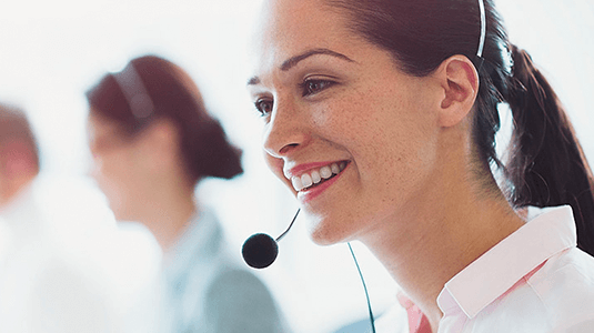 An agent speaking into her headphones to a customer