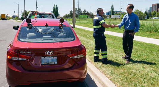 Driver shaking hands with CAA tow truck driver