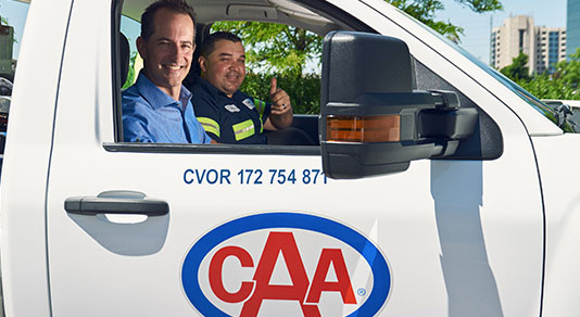 CAA tow truck driver shaking hands with a driver.