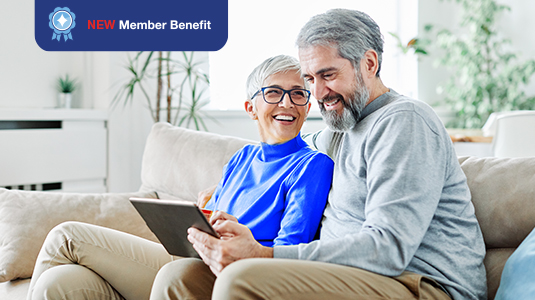 Elderly couple sitting on the couch and looking at a tablet