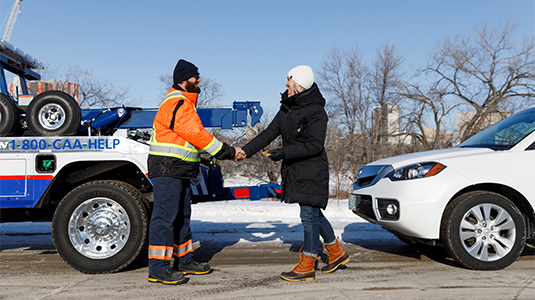 Tow truck driver shaking hands with a member.