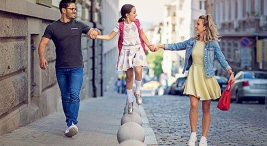 Parents holding hands with daughter