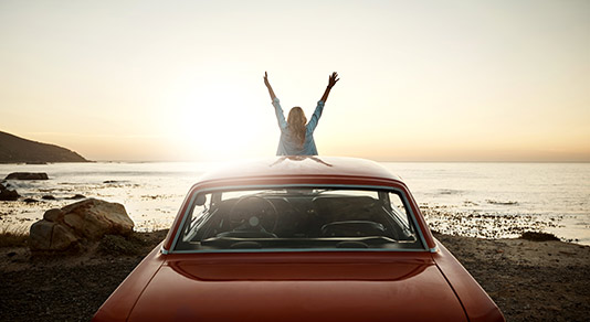 Woman watching sunset in her car