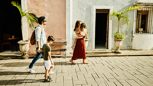 Family walking down street while exploring town during vacation