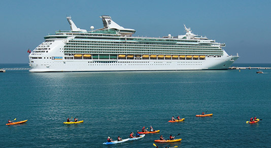 Kayakers in front of a Royal Caribbean cruise ship