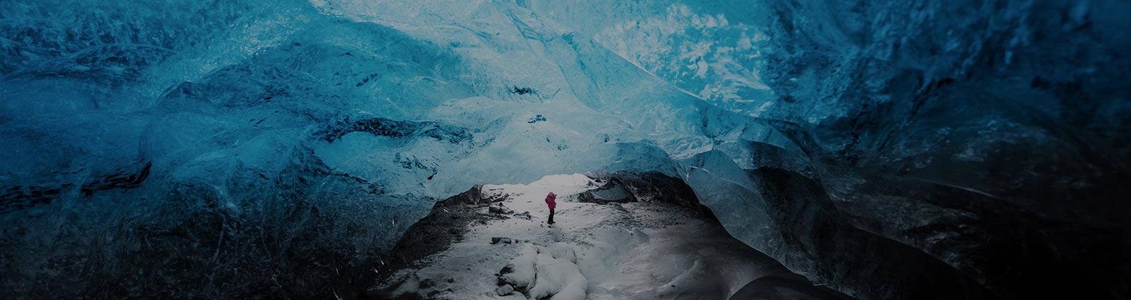 Man traveler exploring ice cave in Vatnajokull glacier, Iceland.