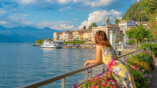 Woman admiring sunset over Lake Como and Bellagio