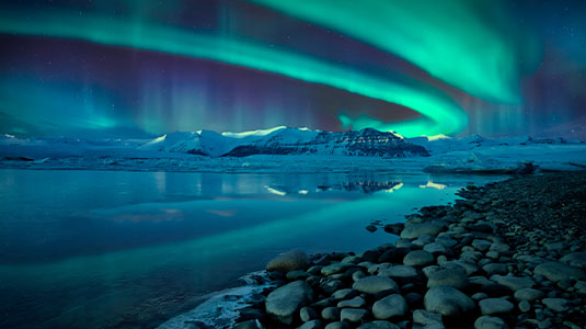 Northern Lights glowing above Jökulsárlón glacier lagoon.