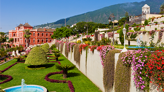 The pink Liceo de Taoro surrounded by gardens and mountains.