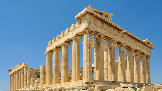 View of the Acropolis and Parthenon against a blue sky.