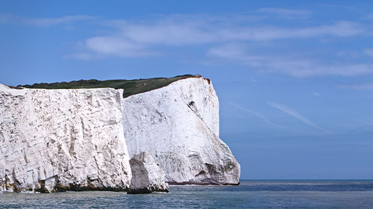 White Cliffs of Dover against a blue sky and sea.