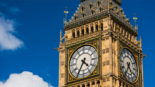 Big Ben clock tower against blue sky and clouds.