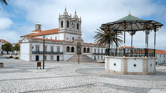 Town square with gazebo leading to a large white church.